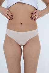 Beige women's briefs on the model. a woman in beige body shorts