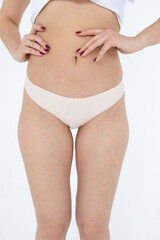 Beige women's briefs on the model. a woman in beige body shorts