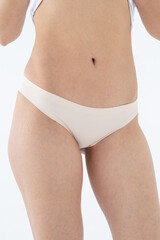 Beige women's briefs on the model. a woman in beige body shorts