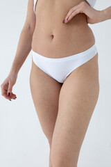 Beige women's briefs on the model. a woman in beige body shorts