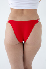 Red women's briefs on the model. young woman's body in red thong panties