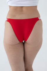 Red women's briefs on the model. young woman's body in red thong panties