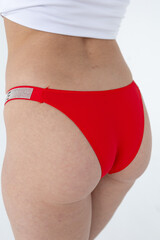 Red women's briefs on the model. young woman's body in red thong panties