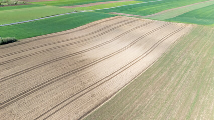 Aerial view of farmland featuring rolling fields and freshly plowed earth, showcasing various...