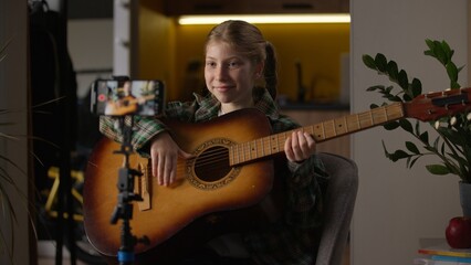 Happy talented Caucasian little girl teen child kid blogger influencer schoolgirl at home recording...