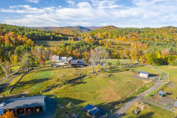 aerial view of Vermont horse farm in fall foliage with barns and home