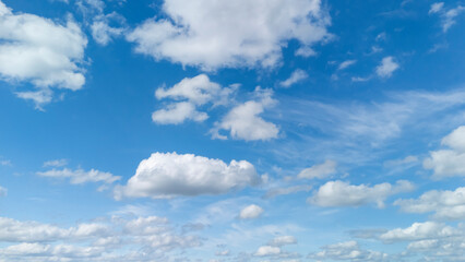 Fototapeta premium Sky filled with white fluffy clouds and bright blue hues creates a serene atmosphere, perfect for nature-themed projects or backgrounds.