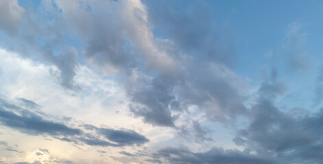 A beautiful sky filled with varying clouds creates a dramatic backdrop during the early evening hours, showcasing shades of blue and gray as the sun sets.