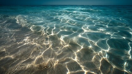 Obraz premium Sunlight reflecting through clear shallow ocean water creating abstract patterns on the sandy seabed