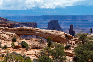 The pothole Mesa Arch (or Rotary Arch and Trail Arch) on the Island in the Sky mesa in Canyonlands National Park, Utah, with views of canyons and the La Sal Mountains in the distance