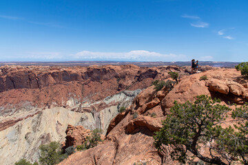 People on cliff on Island in the Sky section of Canyonlands National Park, Utah, USA with geological structure Upheaval Dome interpreted as a meteorite impact structure or a salt dome