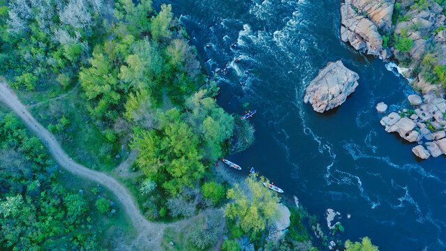 A top-down aerial view of rowers on kayak docking to the coast. - Powered by Adobe