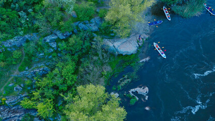 Aerial view of rowers on kayaks docking to the shore.