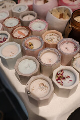 Handmade candles displayed at a craft fair artisanal market. Natural wax candles with decorative designs, showcasing craftsmanship and small business products in a cozy market setting.