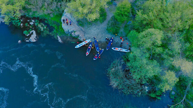 Aerial view of the winning rowers disembarking from boat races on the river.