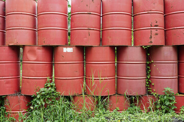 Red barrels lines up in green grass field
