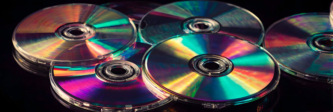 Isolated retro compact disc (CDs), digital video discs (DVD) or CD-ROM. Vintage 90s and 2000s computer technology, music or film media concept graphic or background