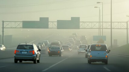Heavy traffic on a highway shrouded in dense fog, creating a hazy and dangerous driving condition - Powered by Adobe