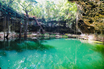 Picturesque sight of the green waters of the X’Canche Cenote, a  natural limestone cavern with a...