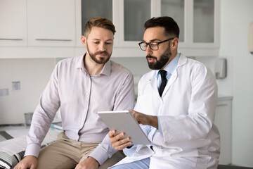 Latin physician doctor in glasses and lab coat explaining medical checkup report, mri examination...