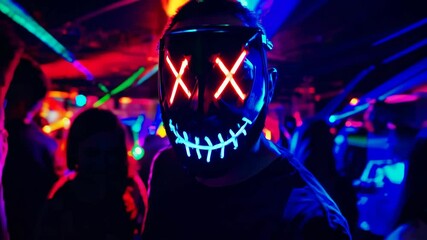 Man with halloween led mask in a party club dancing. Purge film mask