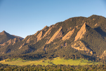 Flatirons Boulder Colorado USA near Denver. Summer sunrise mountain and meadow scene depicting sandstone cliffs and rock formations. Popular area for hiking and rock climbing