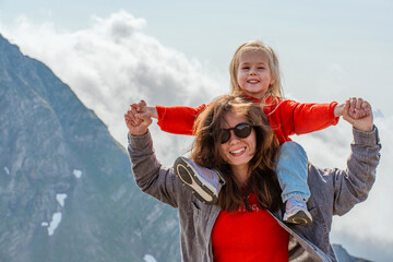 A young mother with her three-year-old child daughter goes to the mountains on Krasnaya Polyana in...