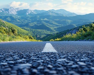 A scenic mountain road surrounded by lush greenery under a blue sky