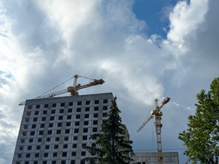 Crane and building construction. construction site. Multi Storey Residential Buildings construction. Tower crane on formworks. Construction crane on Housing. Building site with cranes against sky. 