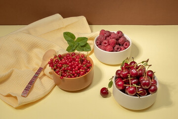 Red fruits of currants, raspberries and cherries in bowls. Health concept. Copy space