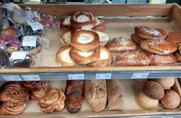 Freshly Baked Rolls and Pastries Available in Bakery Display at Local Shop