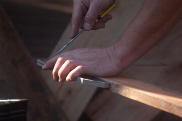 man building his hut with tools