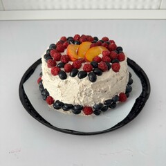 Homemade baby-friendly cake topped with fresh raspberries, blueberries, and peach slices. Perfect healthy dessert for kids’ parties, family gatherings, or summer celebrations.