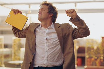 A Joyful Businessman Celebrating His Success in a Modern and Stylish Office Space