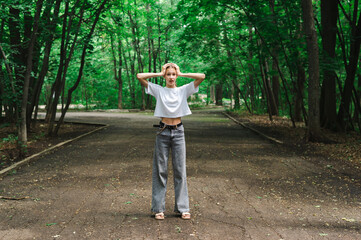 Teenage girl holding her head in horror on a path in the forest