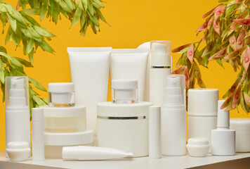 Set of white plastic cosmetic packaging without brand on yellow background. Container for beauty industry, skin care and advertising