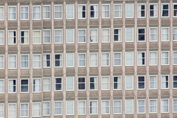 Uniform facade of an apartment building featuring numerous windows, creating a repetitive pattern