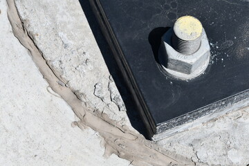 Steel baseplate on power pole. One corner with giant bolt and stud.