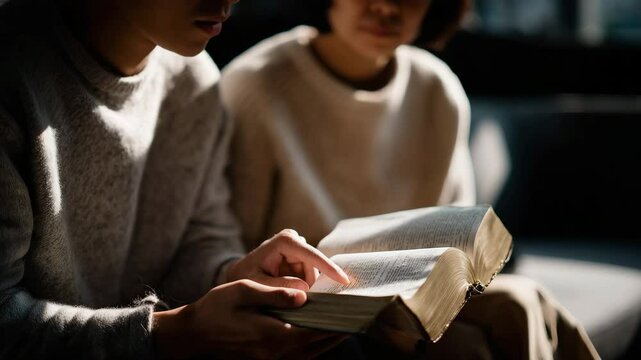 A close-up of two young people reading together, with warm tones and soft lighting