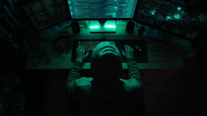 A hacker sits at his desk, surrounded by glowing screens in a dark room - Powered by Adobe