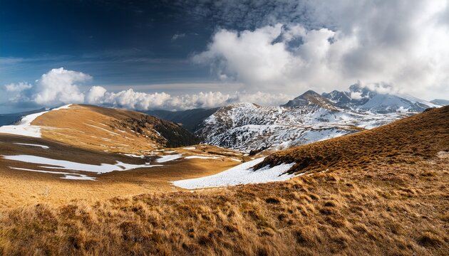 bucegi mountains plateau in romania showing a vast alpine landscape with scattered patches of snow under a dynamic sky mountain trekking romanian wilderness or carpathian travel