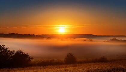 sunrise with glowing orange light and mist over horizon glowing orange sun rising with mist