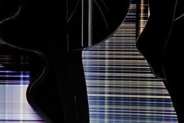 Close-up of a shattered LCD screen displaying colorful glitch patterns, horizontal scan lines, and abstract fractured shapes against darkness.
