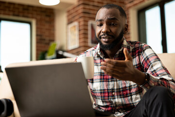 African american man having virtual discussion with investors and shareholders during...