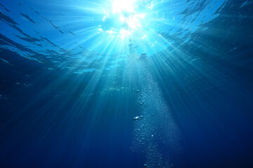 Serene Underwater Scene: Sunbeams Illuminate Rising Bubbles in Deep Blue Ocean Water