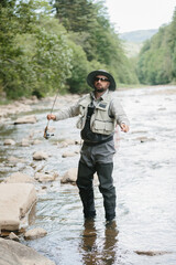 Fisherman casting line in river, enjoying trout fishing adventure
