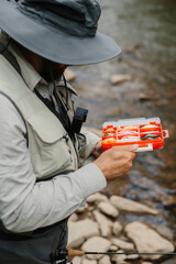 Fisherman choosing fishing lures for trout fishing in river