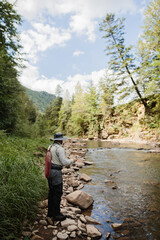 Fisherman fishing trout in a mountain river on a sunny day