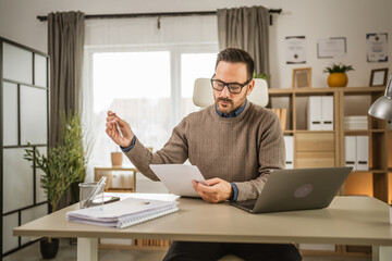 Adult businessman sit at office and prepare to sign the document