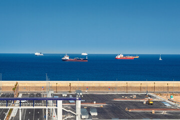 schiffe und frachter auf blauem meer vor einem hafen 